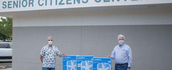 Dirk Roper and Michael Salogga stand in front of the Carson City senior Center with stacks of 24 box fans