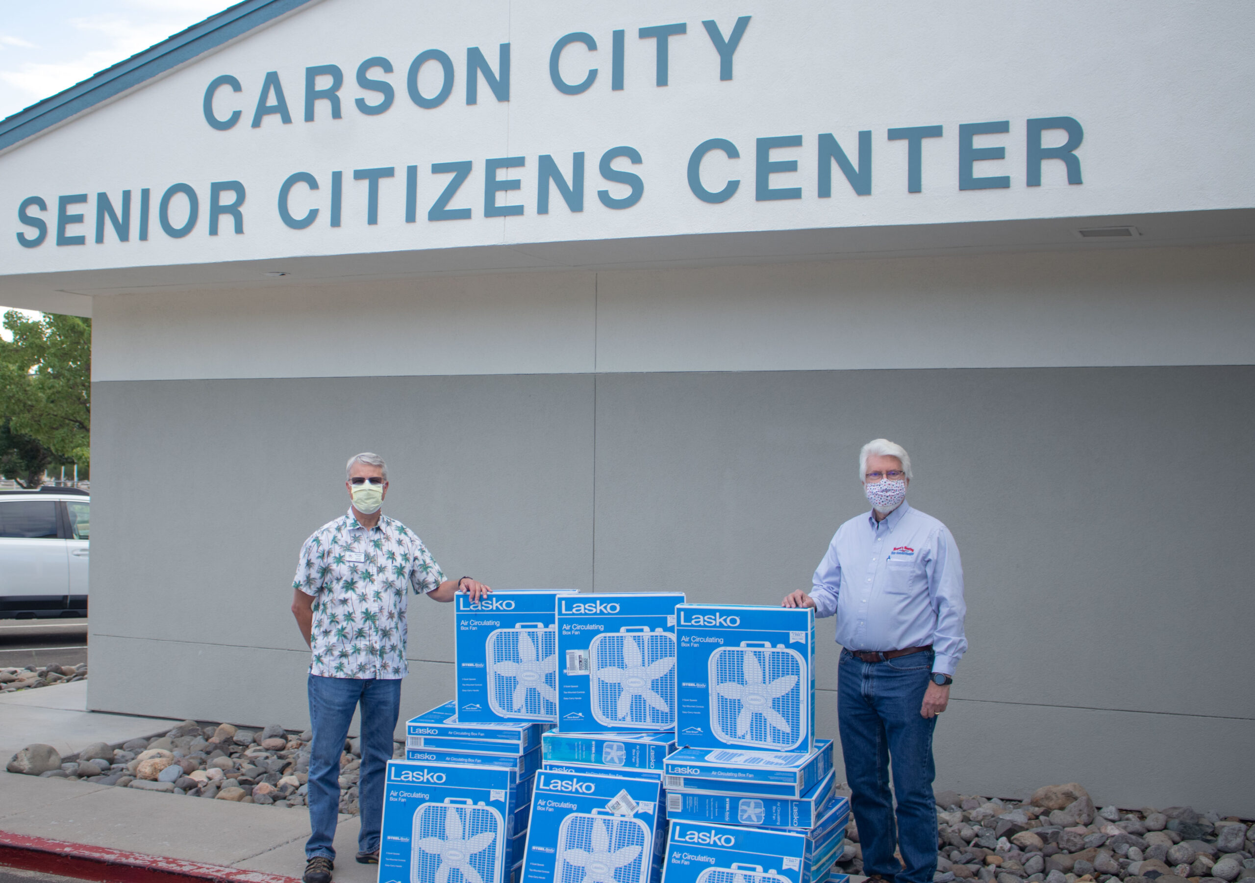 Dirk-and-Michael-scaled Dirk Roper and Michael Salogga stand in front of the Carson City senior Center with stacks of 24 box fans
